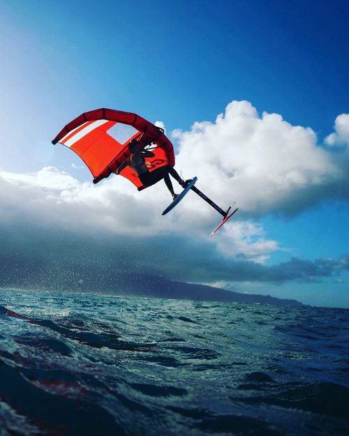 Wing foiler flying above the water on Maui